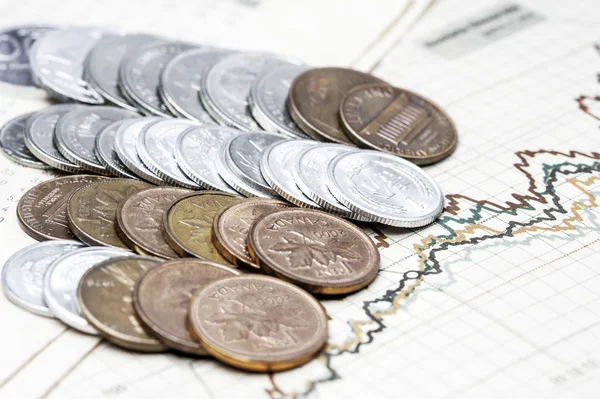 Coins on charts background — Stock Photo, Image