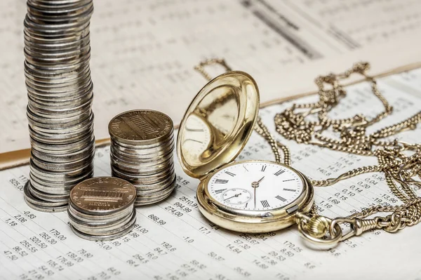 Coins and clock on charts background — Stock Photo, Image