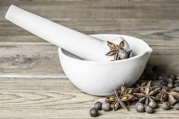 Yenibahar bezelye, yıldız anason ve porselen Harç havaneli ahşap zemin ile