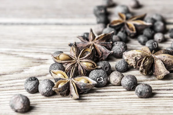 Allspice peas and the star anise on a wooden background — Stock Photo, Image