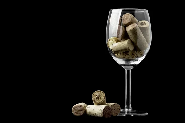 Corchos de vino y una copa de vino sobre fondo negro —  Fotos de Stock