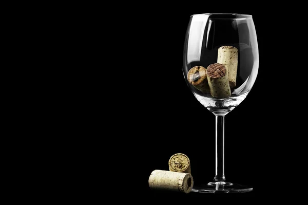 Şarap mantarlar ve siyah bir zemin üzerine bir bardak şarap