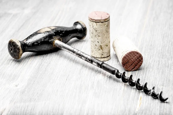 Close-up of corks and  a corkscrew on a wooden  background — Stock Photo, Image