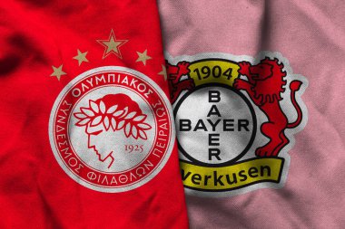 Pringsewu, Lampung; 12 Ocak 2025; Olympiakos Pire ve Bayer Leverkusen logolarının Şampiyonlar Ligi 'nde dalgalı kumaş dokusuyla kombinasyonu.