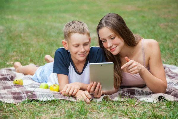젊은 언 니와 동생이 누워 아래로 일 태블릿 — 스톡 사진