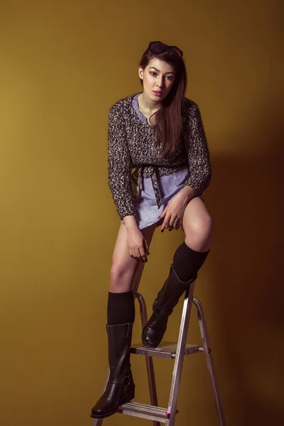 Mixed race sexy fashion model posing on stepladder. — Stockfoto