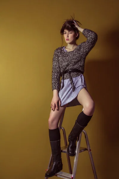 Mixed race sexy fashion model posing on stepladder. — Stockfoto