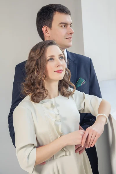 Feliz boda pareja posando en brillante habitación abrazándose mutuamente — Foto de Stock