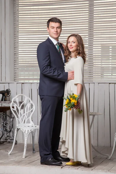 Casal feliz posando em quarto brilhante abraçando uns aos outros — Fotografia de Stock