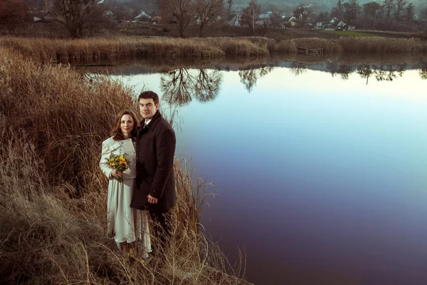 Casal jovem desfrutando de momentos românticos no lago de outono . — Fotografia de Stock