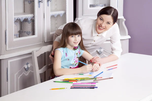 Madre feliz enseña a su hija a pintar . — Foto de Stock