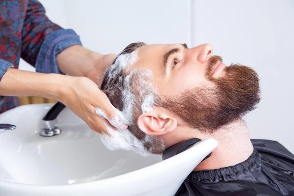 Homme se faisant laver les cheveux dans un salon de coiffure — Photo