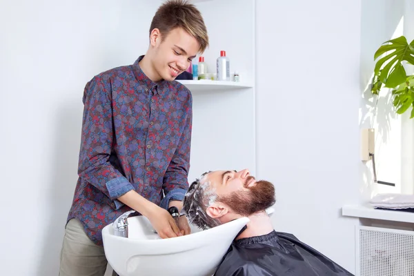 Peluquero peluquero lavado de pelo cliente — Foto de Stock