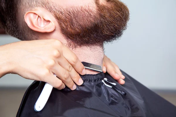 Homme ayant un rasage au salon de coiffure. — Photo