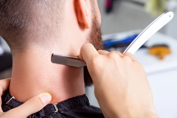 Homme ayant un rasage au salon de coiffure. — Photo