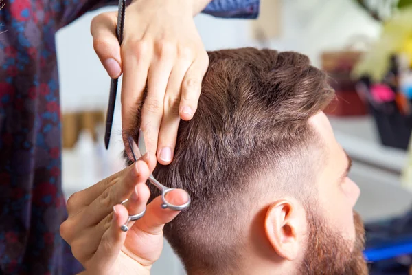 Coiffeur professionnel coiffant les cheveux de son client — Photo