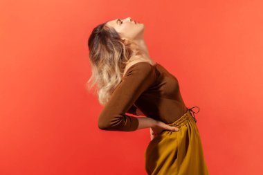 Sırt ağrısı. Akut ağrı ve sırt ağrısı içinde bağıran, böbrek taşı hastalığı riski taşıyan, sinir sıkışması olan sağlıksız bir kadının portresi. Kırmızı arkaplanda kapalı stüdyo çekimleri