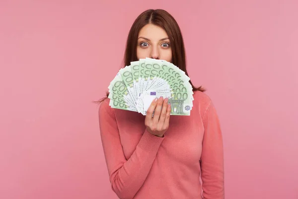 분홍색 스웨터를 여성이 지폐의 얼굴을 숨기고 스튜디오 배경에서 고립되어 — 스톡 사진