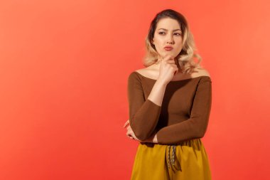 Kahverengi bluzlu, düşünceli, üzgün bir kadının portresi. Durup ciddi meseleler üzerinde kafa yoruyor. Belirsiz bir ifadeyle yana bakıyor, zor seçimler yapıyor. Kırmızı arkaplanda kapalı alan