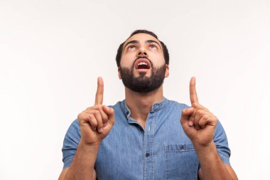 Şaşırmış, sakallı, yön gösteren, boş yerleri işaret eden, boş alana dikkatinizi veren bir adam. Beyaz arka planda izole edilmiş kapalı stüdyo görüntüleri