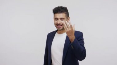 İş elbisesi içinde duygusal açıdan başarılı bir adam kamerayla konuşuyor hareketli, kendine güvenen yaşam koçu çevrimiçi ders veriyor. Gri arka planda izole edilmiş kapalı stüdyo görüntüleri