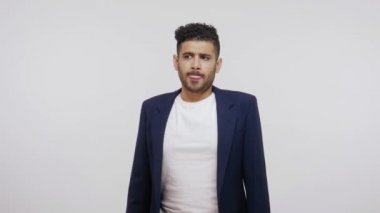 İş elbisesi giymiş, sakallı, düşünceli, düşünceli bir adam çenesini ovalıyor, işe başlamak için fikirler düşünüyor, iş projesini düşünüyor. Gri arka planda izole edilmiş kapalı stüdyo görüntüleri