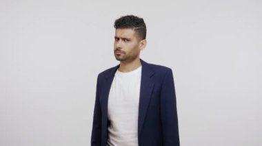 Takım elbiseli ciddi sakallı bir adam el hareketini durduruyor ve öfkeyle kameraya bakıyor çatışmaları reddediyor, yasaklıyor. Gri arka planda izole edilmiş kapalı stüdyo görüntüleri