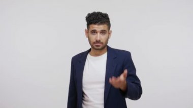 Sus, konuşma! Dudaklarının yanında sakallı, çenesini kapamasını isteyen, özel sırlar saklayan, ihanetten şüphelenen ciddi agresif bir adam. Gri arka planda izole edilmiş kapalı stüdyo görüntüleri