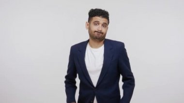 Hüsrana uğramış, sakallı, boş cepli, kameraya üzüntüyle bakan, işini kaybeden, tüm parasını, yoksulluğunu, borçlarını gösteren bir adam. Gri arka planda izole edilmiş kapalı stüdyo görüntüleri