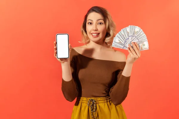 Szczęśliwa Atrakcyjna Kobieta Trzymając Biały Ekran Smartfon Fanem Dolarów Patrząc — Zdjęcie stockowe