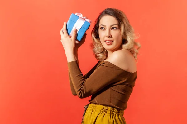 Neugierige Attraktive Frau Schüttelt Blaue Geschenkbox Mit Rosa Schleife Versucht — Stockfoto