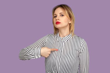 Ben buyum! Mükemmel kırmızı dudakları olan, kendini gösteren, kibirli bir ifadeyle bakan, gururlu ve kendine güvenen güzel sarışın bir kadın. Mor arka planda izole edilmiş kapalı stüdyo çekimi