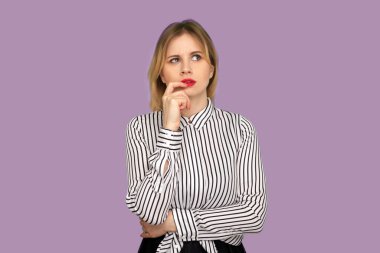 Güzel düşünceli, kırmızı dudaklı, çizgili bluzlu, düşünceli, zeki bir ifade takınıp kuşkuyla cevap veren güzel bir kadın. Mor zemin üzerinde kapalı çekim izole