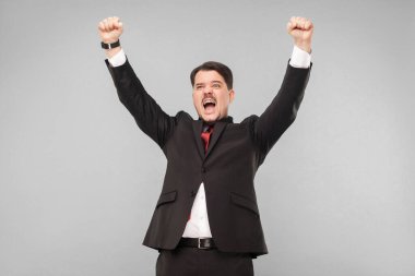 Kazanan işadamı ihaleyi kazandı ve bütün rakiplerini dolaştı. Şimdi kutlama zamanıdır. Kapalı, gri arka planda izole edilmiş. Siyah takım elbiseli ve bıyıklı bir iş adamı başka tarafa bakıyor..