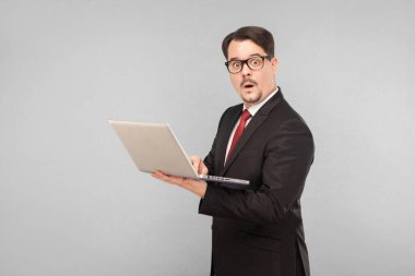 İş, aletler, teknolojiler. Shok 'taki adam. Not defterini tutuyorum. İçerde, stüdyoda, gri arka planda izole edilmiş.