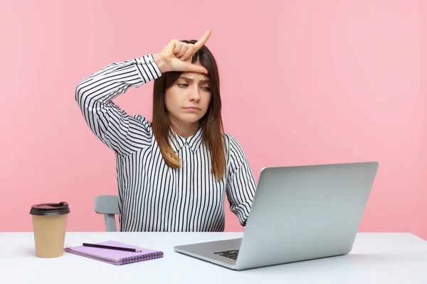 Depressed upset woman office worker showing loser gesture communicating on video call, sad about her dismissal, desperate about unlucky day. Indoor studio shot isolated on pink background