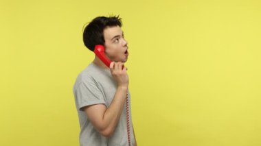 Profil portresi, elinde kırmızı bir cep telefonu olan, akrabalarıyla konuşan, dikkatlice dinleyen ve soruları cevaplayan sıkılmış genç bir adam. Sarı arka planda kapalı stüdyo çekimleri
