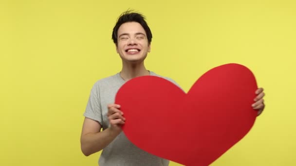 Надзвичайно Щасливий Молодий Дорослий Чоловік Тримає Велике Червоне Паперове Серце — стокове відео