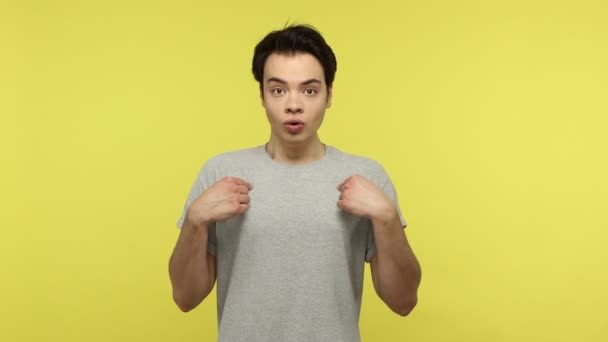 Gri Tişörtlü Şaşkın Genç Adam Kendini Işaret Ediyor Inanılmaz Haberlere — Stok video