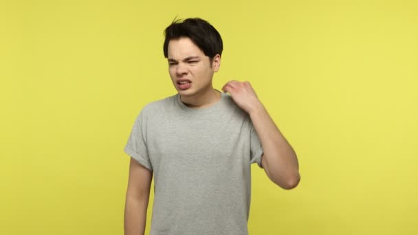 Erschöpfter Junger Mann Lässigen Grauen Shirt Reibt Sich Schmerzenden Nacken — Stockvideo