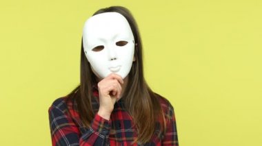 Çoklu kişilik. Kareli tişörtlü kadın farklı duygular gösteriyor, maskesini çıkarıyor, yüz ifadelerini değiştiriyor, mutluluk şaşkına dönüyor. Sarı arka planda kapalı stüdyo çekimleri