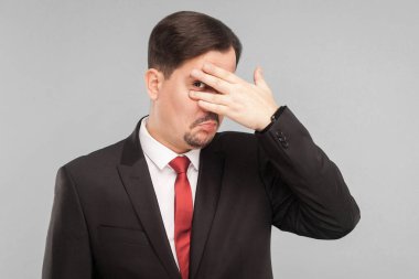 Merakımdan soruyorum, merakımdan soruyorum. Kapalı stüdyo çekimi. Gri arka planda izole. Siyah takım elbiseli, kırmızı kravatlı ve bıyıklı yakışıklı işadamı kameraya bakıyor..