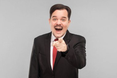 Komik durumdaki bir adam ya da peri ordusundaki bir video ve bu onu güldürürdü. Kapalı stüdyo çekimi. Gri arka planda izole. Bıyıklı yakışıklı iş adamı kameraya bakıyor..