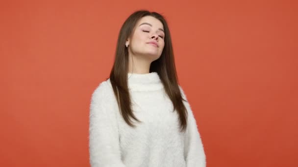 白いふわふわのセーターを身に指を指して 誇りと自己満足し 自己の重要性を感じ 魅力的な利己的な女性 オレンジの背景に隔離された屋内スタジオショット — ストック動画