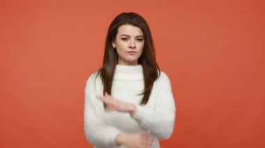 İmkanı yok. Kahverengi saçlı, beyaz kazaklı, elleri ve girişi kısıtlı x işareti gösteren ciddi patronluk taslayan bir kadın. Bu son, vücut dili. Turuncu arka planda kapalı stüdyo çekimleri