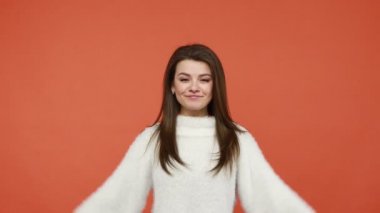 Tüylü beyaz süveter giyen, başını sokacak çatı yapan, emniyette hisseden, daire kiralayan, acente vasıtasıyla, sigorta konseptiyle gülümseyen pozitif bir kadın. Turuncu arka planda kapalı stüdyo çekimleri