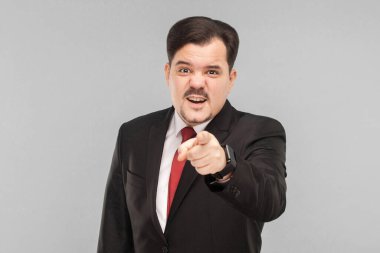 Hey sen! Takım elbiseli bir adam kamerayı işaret ediyor. Sen miydin? Yalan söylediğinize inanmıyorum. Kapalı stüdyo çekimi. Gri arka planda izole. Siyah takım elbiseli, kırmızı kravatlı ve bıyıklı iş adamı.