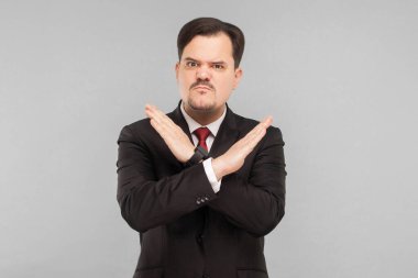 X işareti gösteren bir adam. Kötüye işaret. Sakın beni bu kapalı stüdyo çekimini yapmaya ikna etmeye çalışma. Gri arka planda izole. Siyah takım elbiseli, kırmızı kravatlı ve bıyıklı yakışıklı bir iş adamı..