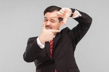 Hayal gücü konsepti. Mimar inşaattan sonra binanın nasıl görüneceğini temsil ediyor. Kapalı, gri arka planda izole edilmiş. Siyah takım elbiseli, kırmızı kravatlı ve bıyıklı yakışıklı bir iş adamı.