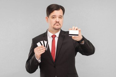 Bir banka kartı diğer tüm kartlarının yerini alacak. İçerde, stüdyoda, gri arka planda izole edilmiş.